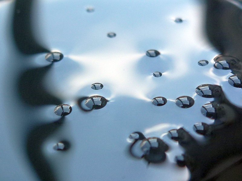 Wassertröpfchen auf bzw. in Sonnenblumenölfleck