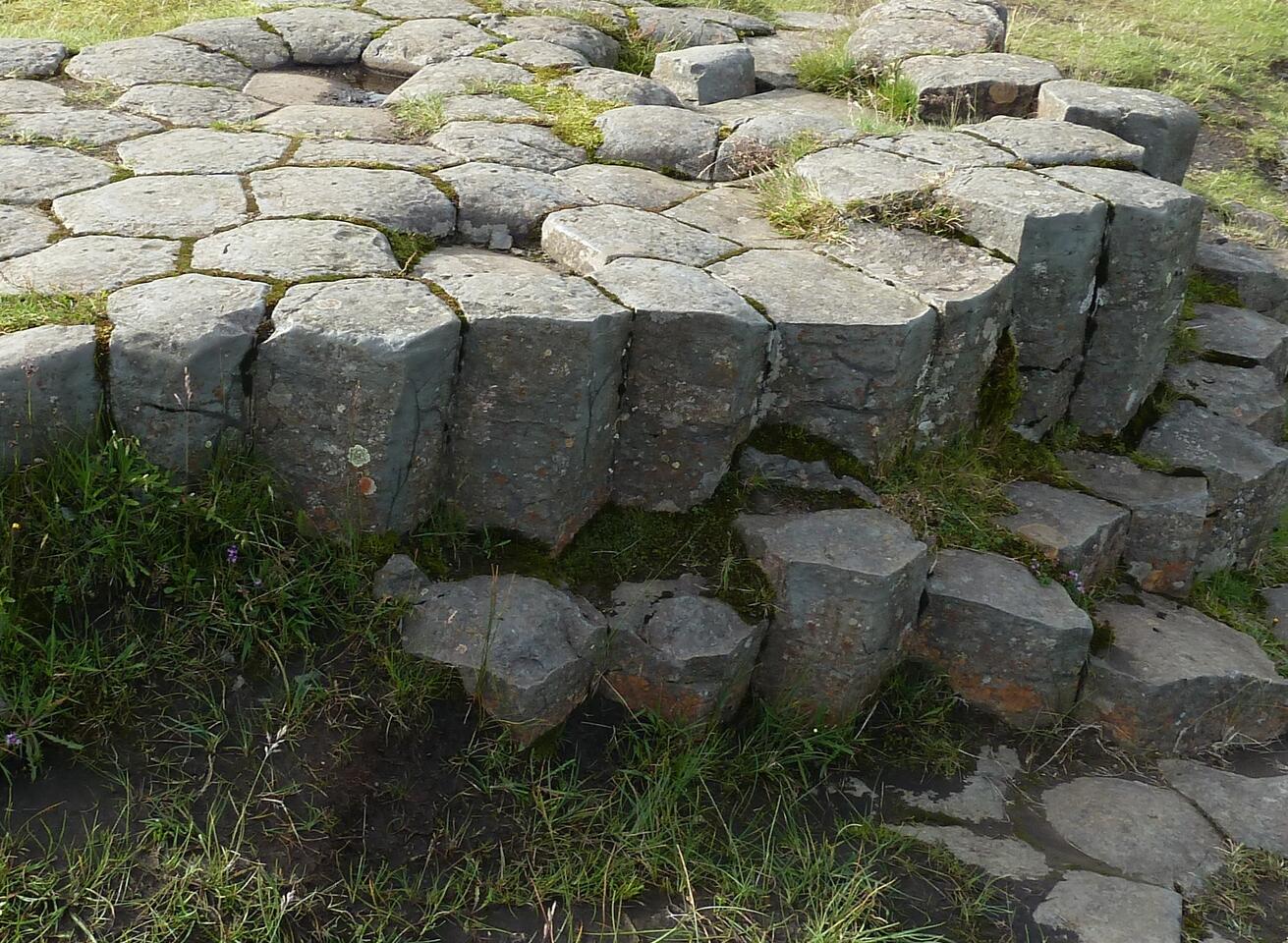 Basaltsäulen am Kirkjugárd; eine Struktur aus mehreckigen Formen, die an eine Pflasterung erinnert; (c) Stephan Matthiesen 2011