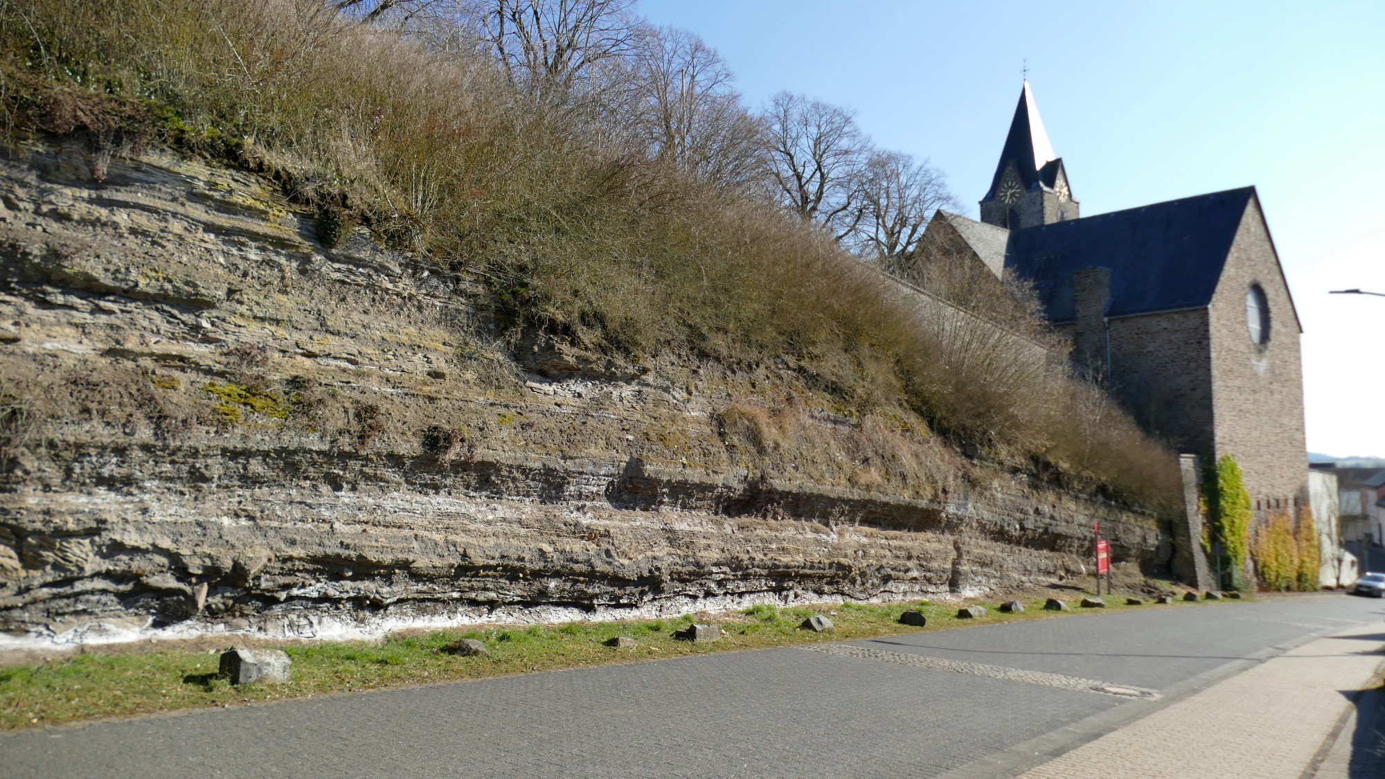 Neben der Kirche von Ulmen sind die unterschiedlichen Tuff-Schichten der Eruptionen der Eifelvulkane gut zu erkennen.